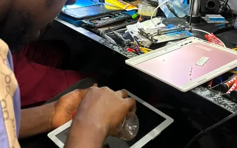 Technicien KLM-TECH ouvrant une tablette au comptoir de l'atelier