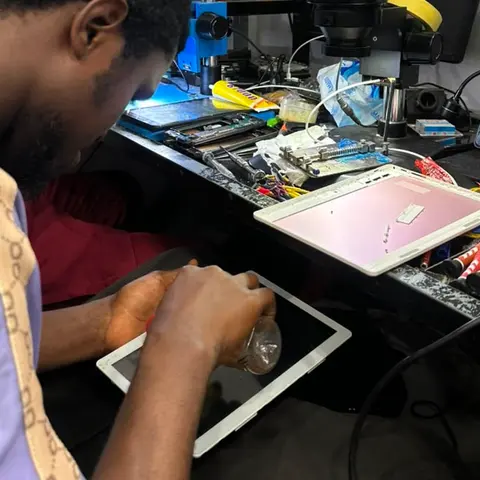 Technicien KLM-TECH ouvrant une tablette au comptoir de l'atelier